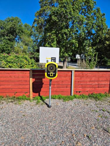a yellow parking meter in front of a fence at Trosa Vandrarhem in Trosa