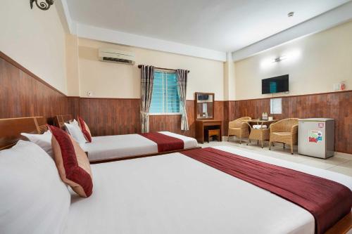a hotel room with two beds and a television at Dancenter Phuong Nam Hospital Formerly Nam Phuong Hoang Hau in Ho Chi Minh City