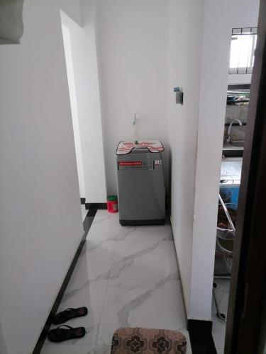 a hallway with a small refrigerator in a room at Charming Home in Negombo