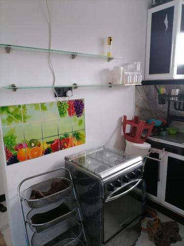 a kitchen with a stove and a painting on the wall at Charming Home in Negombo