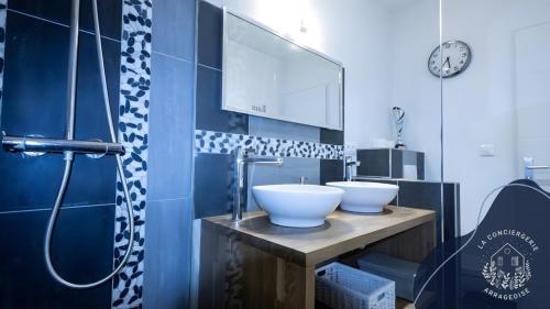 a bathroom with two white sinks on a wooden counter at La terrasse, proche des places 2 chambres in Arras
