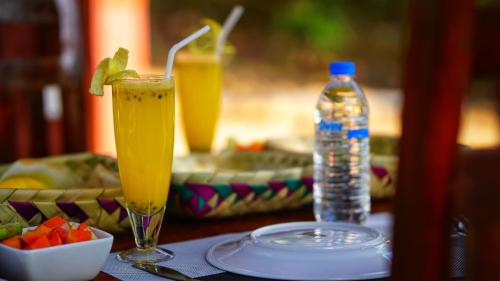 a table with a drink and a bottle of water at Jungle Crown Cabin in Sigiriya