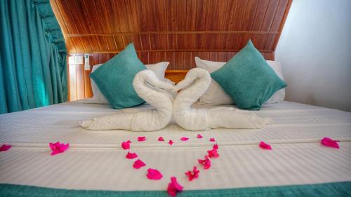 two swans making a heart on a bed at Jungle Crown Cabin in Sigiriya