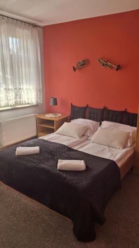 a bedroom with a large bed with two towels on it at Dom Pracy Twórczej in Gryfice
