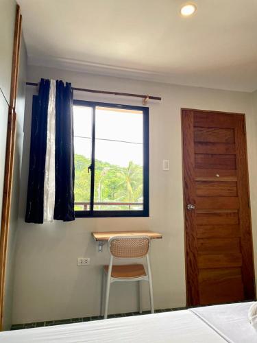 a bedroom with a desk and a window and a chair at Chill Out Hostel in Boracay