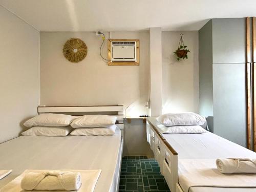 a room with two beds and a air conditioner at Chill Out Hostel in Boracay