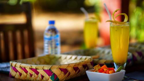 a table with a plate of food and a drink at Jungle Crown Cabin in Sigiriya