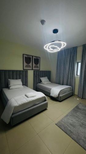a bedroom with two beds and a chandelier at sharjah,kalba 