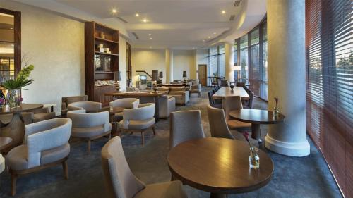a restaurant with wooden tables and chairs andwindows at Conrad Istanbul Bosphorus in Istanbul