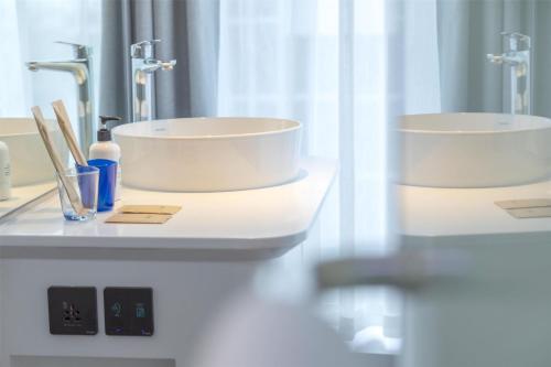 a bathroom with two sinks and two mirrors at Tru by Hilton Viet Tri City Centre in Việt Trì