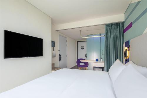 a hotel room with a bed and a flat screen tv at Tru by Hilton Da Nang City Centre in Da Nang