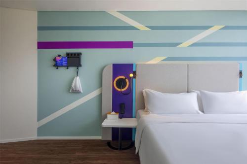 a bedroom with a bed and a colorful wall at Tru by Hilton Da Nang City Centre in Da Nang