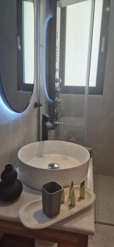 a bathroom with a white sink and a mirror at Thalori Suites in Kalamata