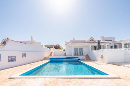 a swimming pool in the backyard of a house at Casa Dos Amigos in Budens
