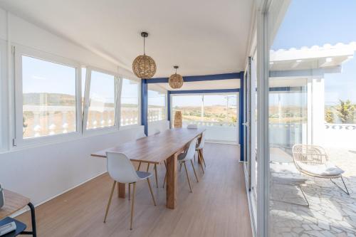 a dining room with a wooden table and chairs at Casa Dos Amigos in Budens