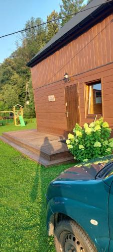 a smallshed with a car parked in front of it at Domki przy Młynie " Koło Młyńskie " in Krościenko