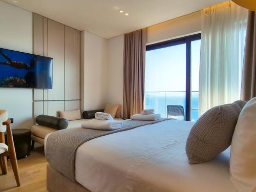 a hotel room with a large bed and a large window at Rêve Studio Apartments in Sarandë