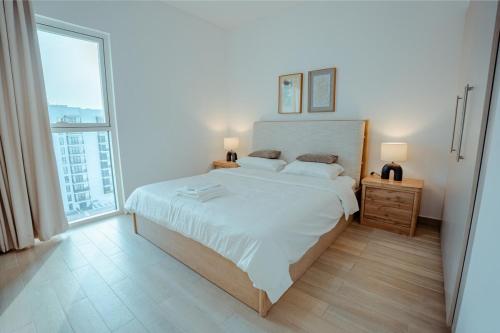 Un dormitorio con una cama grande y una ventana grande en Modern 1BR with Lake View Yas Island Stay for 4, en Abu Dabi