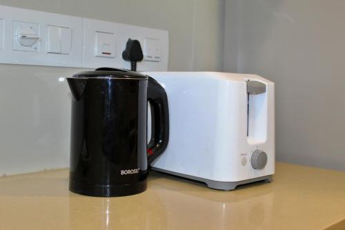 a white toaster sitting on top of a counter at Maxxvalue Apartment Hiranandani Powai - RH5 in Mumbai