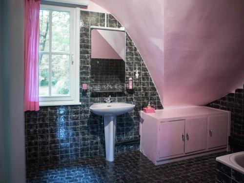a pink bathroom with a sink and a mirror at Westmalle Forest Garden Home in Zoersel