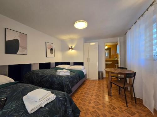 a hotel room with two beds and a table at Willa Mira 200 metrów od morza in Międzyzdroje