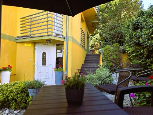 a yellow building with a table and an umbrella at Willa Mira 200 metrów od morza in Międzyzdroje