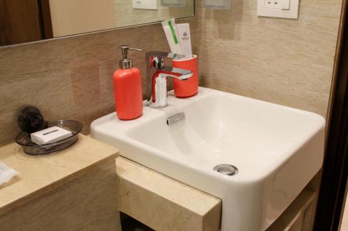 Un lavabo de baño con un extintor rojo encima. en Maxxvalue Apartment Hiranandani Powai - RH5, en Bombay