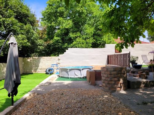 a backyard with a swimming pool and an umbrella at Kastély Ház in Sály