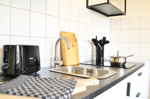 a kitchen counter with a sink and a coffee maker at MILPAU Bottrop 2 - Premium-Apartment - 4 Personen mit Queensize-Bett und Einzelbetten - Zentral, Nespresso und Smart-TV in Bottrop