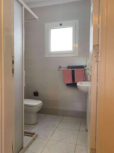 a bathroom with a toilet and a sink and a window at Delta sharm in Sharm El Sheikh
