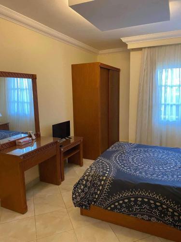 a bedroom with a bed and a desk with a computer at Delta sharm in Sharm El Sheikh