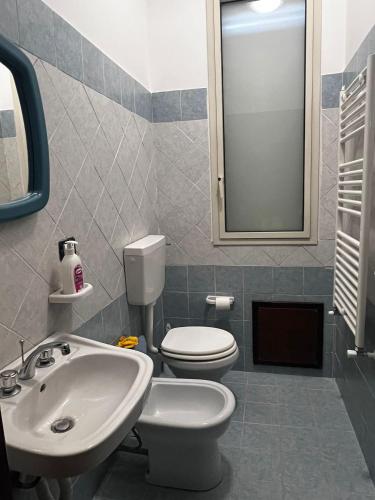 a bathroom with a white toilet and a sink at West Sicily Beach in Balestrate