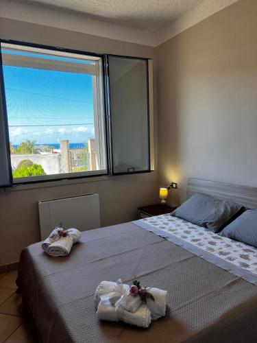 a bedroom with a bed and a large window at West Sicily Beach in Balestrate