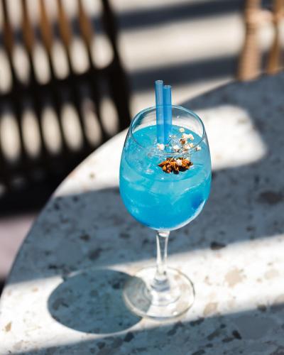 a blue drink in a glass sitting on a table at Hotel City IN in Kochani