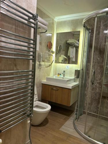 a bathroom with a shower and a toilet and a sink at Burdur Park Prestij Otel in Burdur