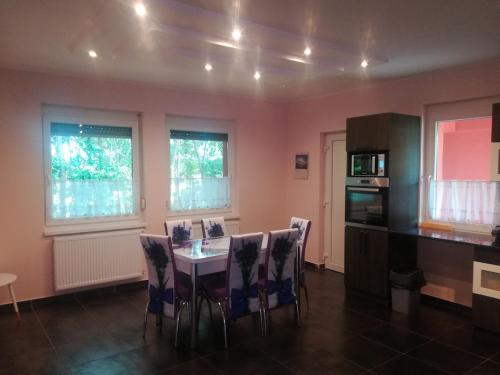 a kitchen with a table and chairs in a room at Designed by love in Mikepércs