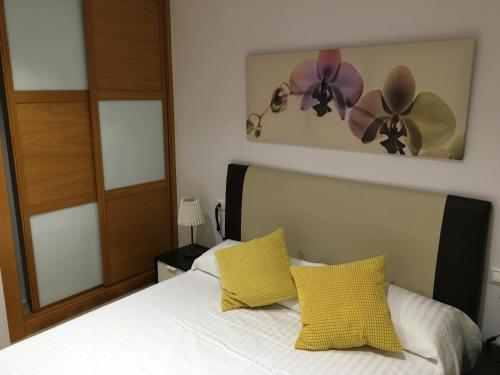 ベニドルムにあるCasa Candelariaのベッドルーム1室(壁に黄色と紫の花を用いたベッド1台付)