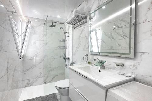 a white bathroom with a sink and a shower at Fantastic vacation by the ocean in Playa de las Americas