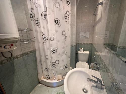 a bathroom with a sink and a shower curtain at Triumph Holiday Village in Sveti Vlas