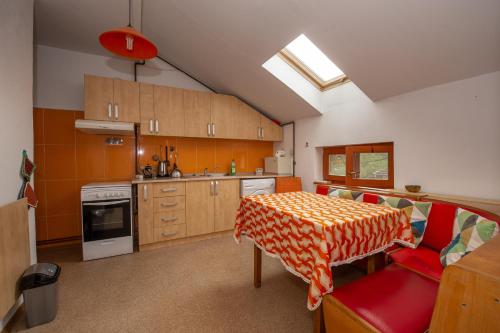 a kitchen with a table and a red chair with a table cloth at Gästehaus Fogarasch in Făgăraş