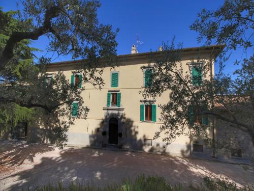 a large white building with green shutters on it at Farmhouse in Umbria near Lake Trasimeno in Gualdo Cattaneo