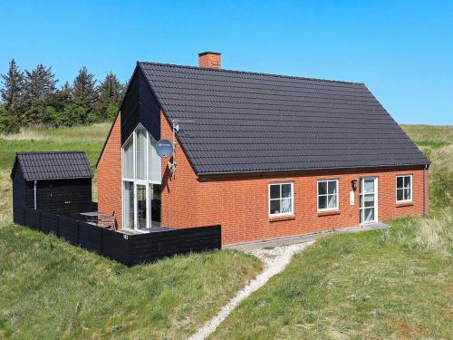 a small red brick house in a field at Secluded Retreat near Beach - By Traum Ferienwohnungen in Vigsø