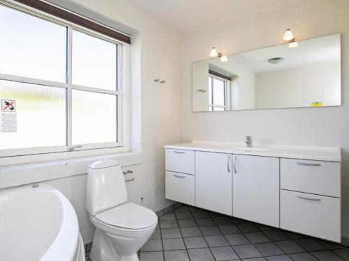 a bathroom with a toilet and a sink and a mirror at Secluded Retreat near Beach - By Traum Ferienwohnungen in Vigsø