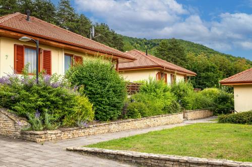 a house with a stone walkway in front of a yard at Szalajka Liget Hotel és Apartmanházak in Szilvásvárad