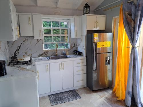 a kitchen with white cabinets and a stainless steel refrigerator at Content Studio in Saint Thomas