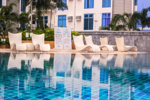 a row of white chairs next to a swimming pool at Nap Trap in Cebu City