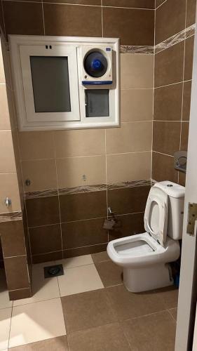 a bathroom with a toilet and a tv on the wall at Delta n1 Sharm in Sharm El Sheikh
