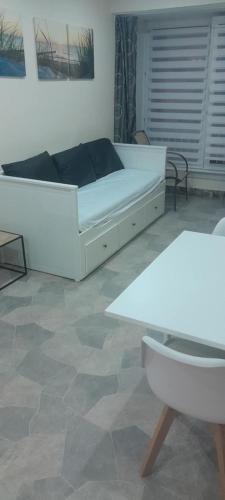 a bedroom with a white bed and a table at Heïdi 7 in Middelkerke
