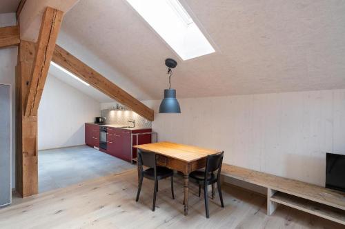 a dining room with a table and chairs in a attic at Bijou Biobergün in Bergün