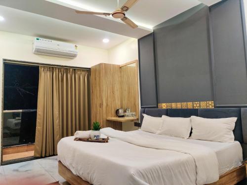 a bedroom with a large white bed and a window at Hotel The Argal By Basotel, Vijay Nagar in Indore